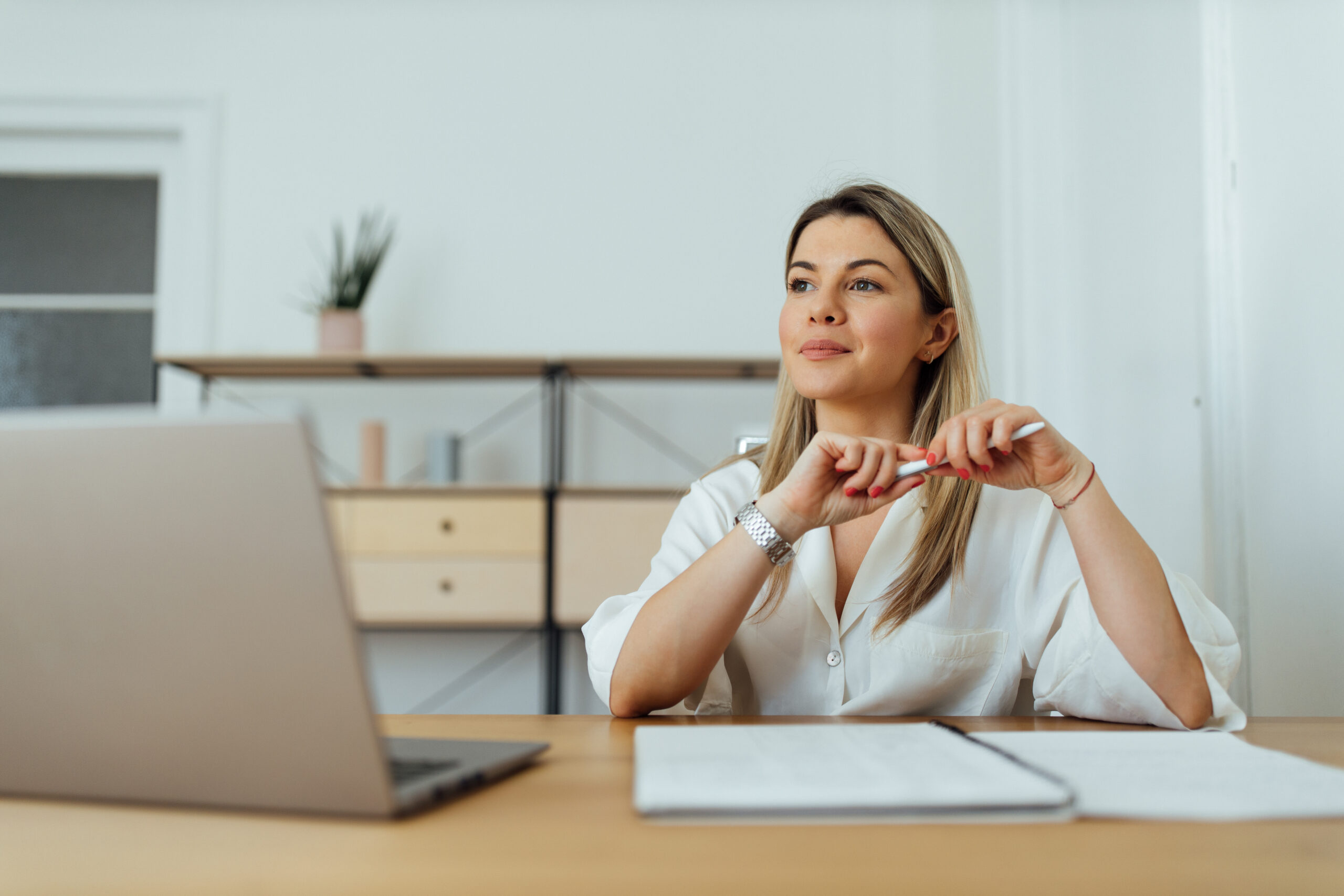 Blonde vrouw aan een bureau met een pen die zich inleest over de ketenbepaling