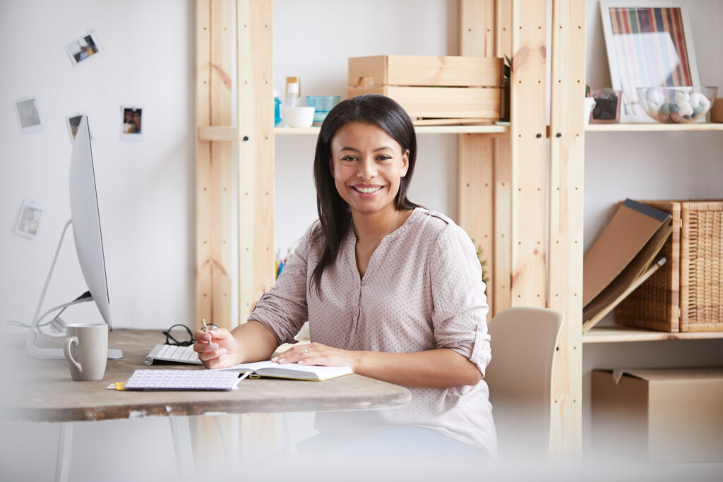 Vrouwelijke medewerker aan een bureau met notitiespullen aan het schrijven over de ketenbepaling