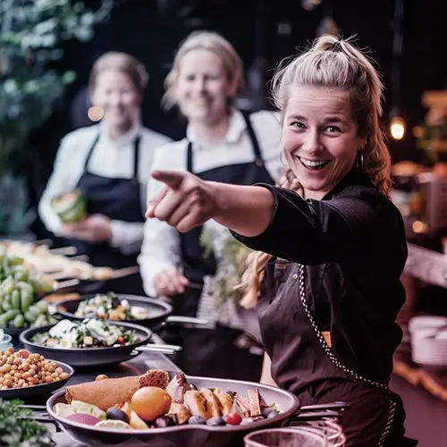 Vrouw glimlachend achter een bar, symbool voor persoonlijk advies en ondersteuning bij payrolling via Payroll Select.